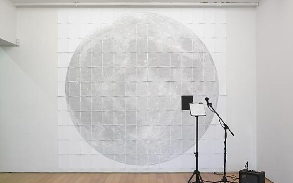 Microphone stands in front of an image of the moon
