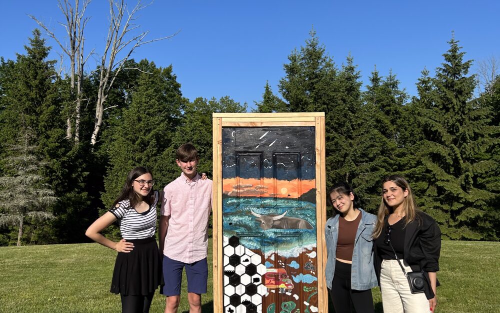 Students with artist Hangama Amiri (at right) with their door installation in The Aldrich's Sculpture Garden.