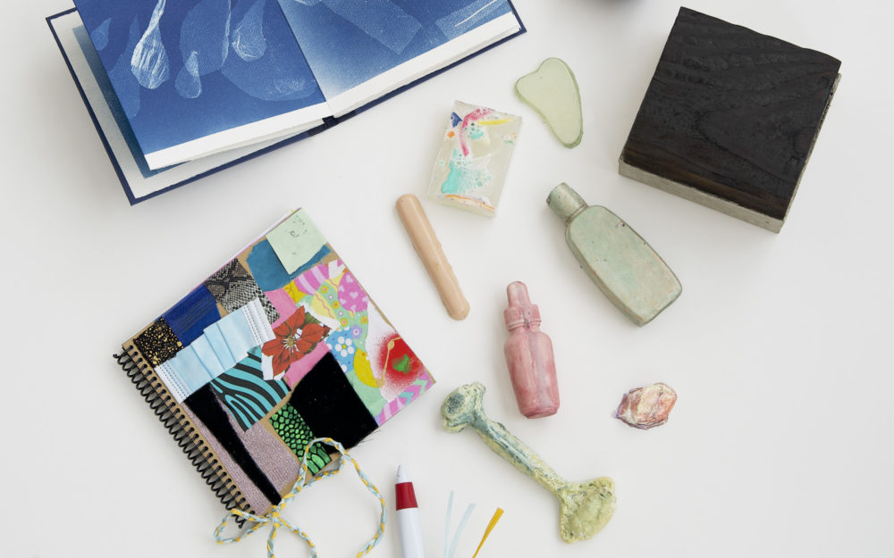 The art contents of the Aldrich Care Box featuring two artists' books and small sculptures.