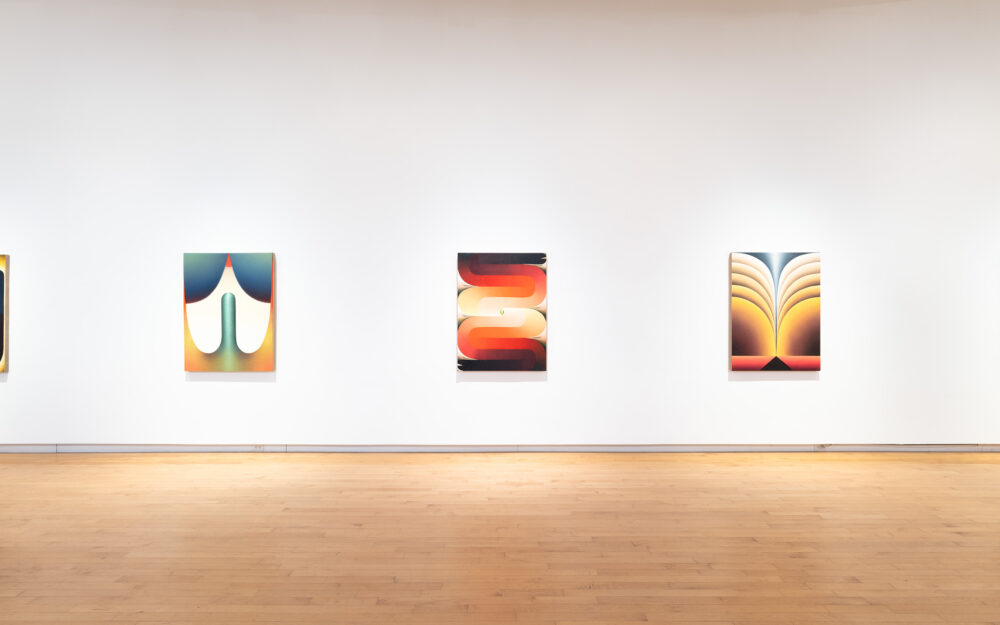 Colorful paintings hung in a row.