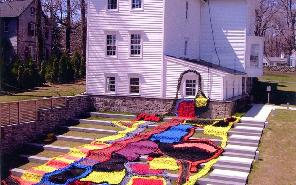 Outdoor Installation:Multi-colored, amorphous crocheted shapes create a sculpture that climbs up steps that lead from the museummto the administrative building.