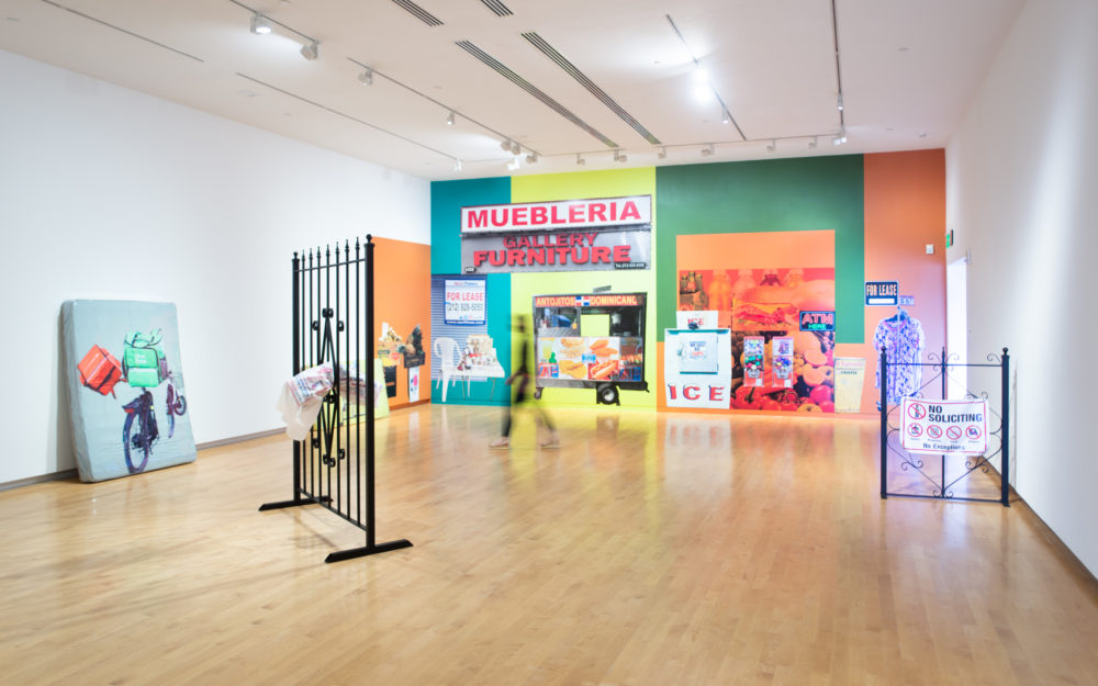 Gallery with two large metal gate sculptures and a colorful wall mural