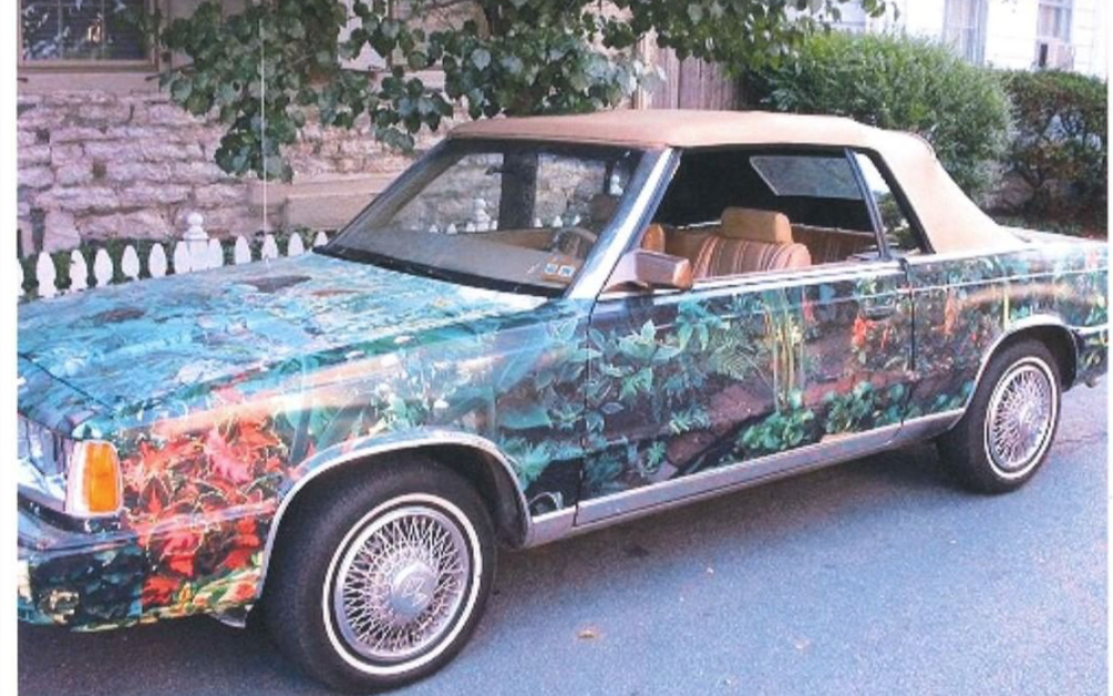 1985 Chrysler LeBaron decorated with leaves of various colors