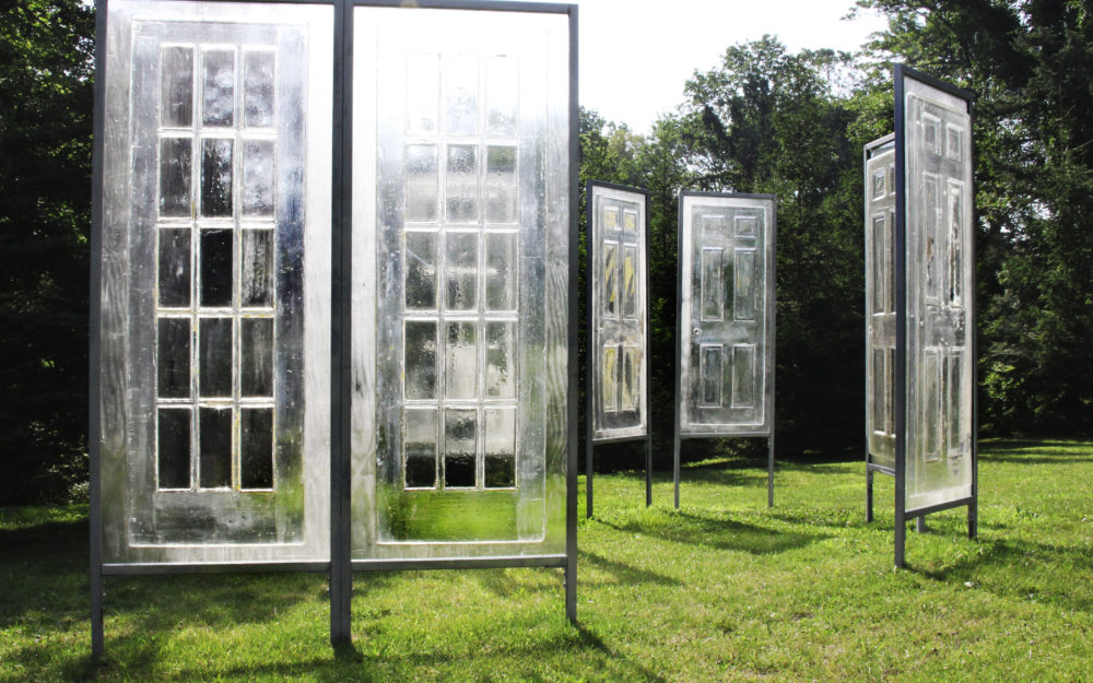 Clear window panels stand up right on a green lawn