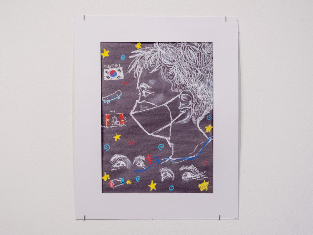 A pastel drawing of a boy's profile surrounded by various iconography on black paper.