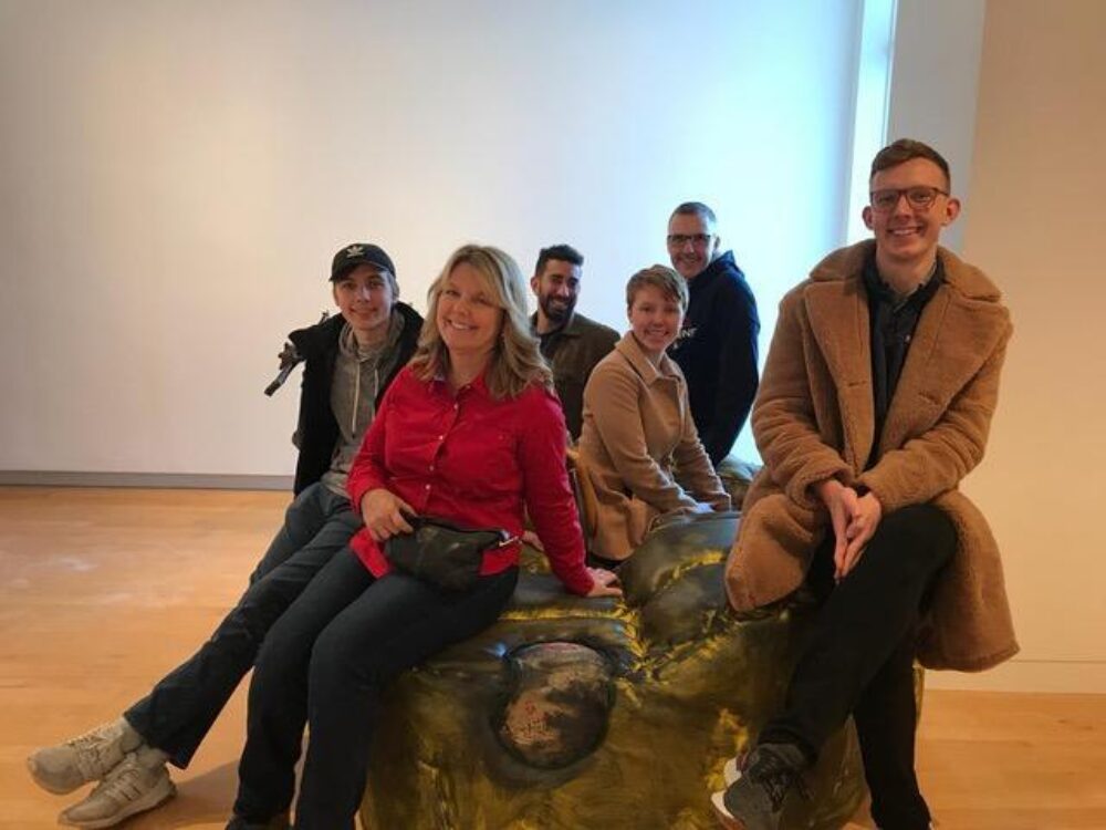 A family sitting on an artwork in a gallery