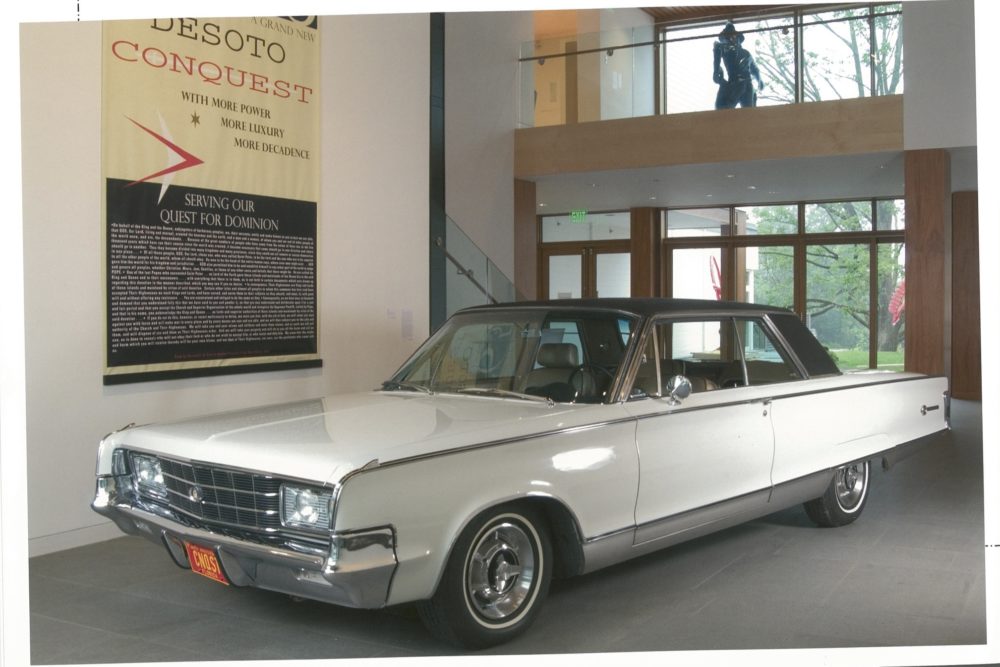 White Desoto(car) with advertisement text on right wall installed in Museum atrium gallery