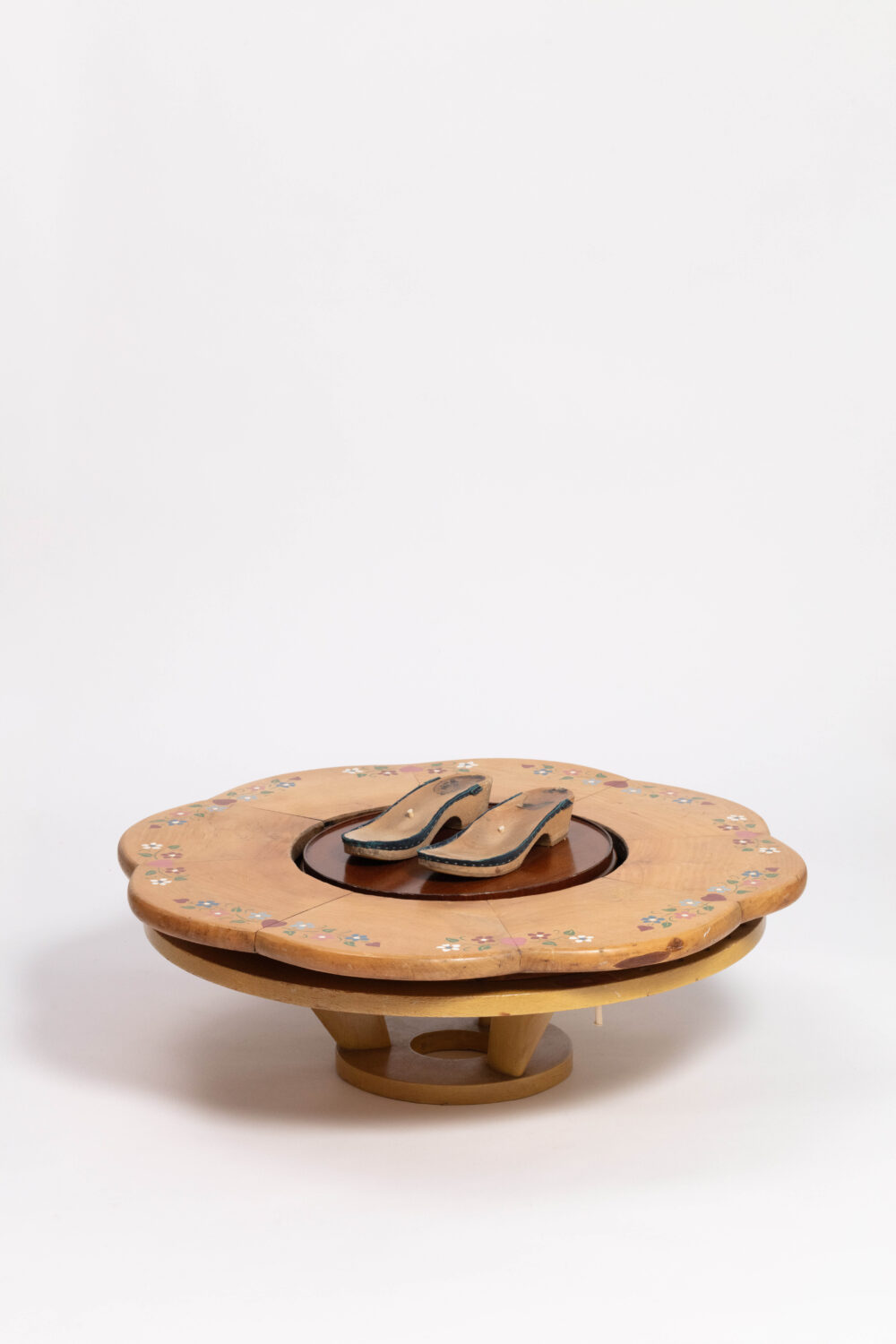 A wooden platform with the wooden soles of a pair of clogs on top.