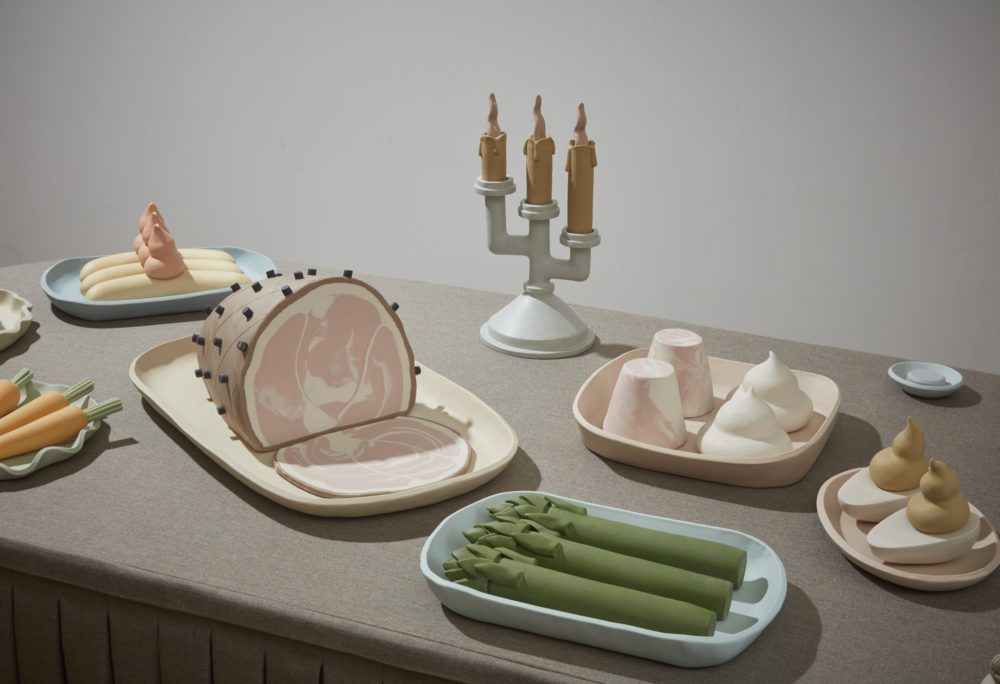 Small sculptural food items arranged on a gray table