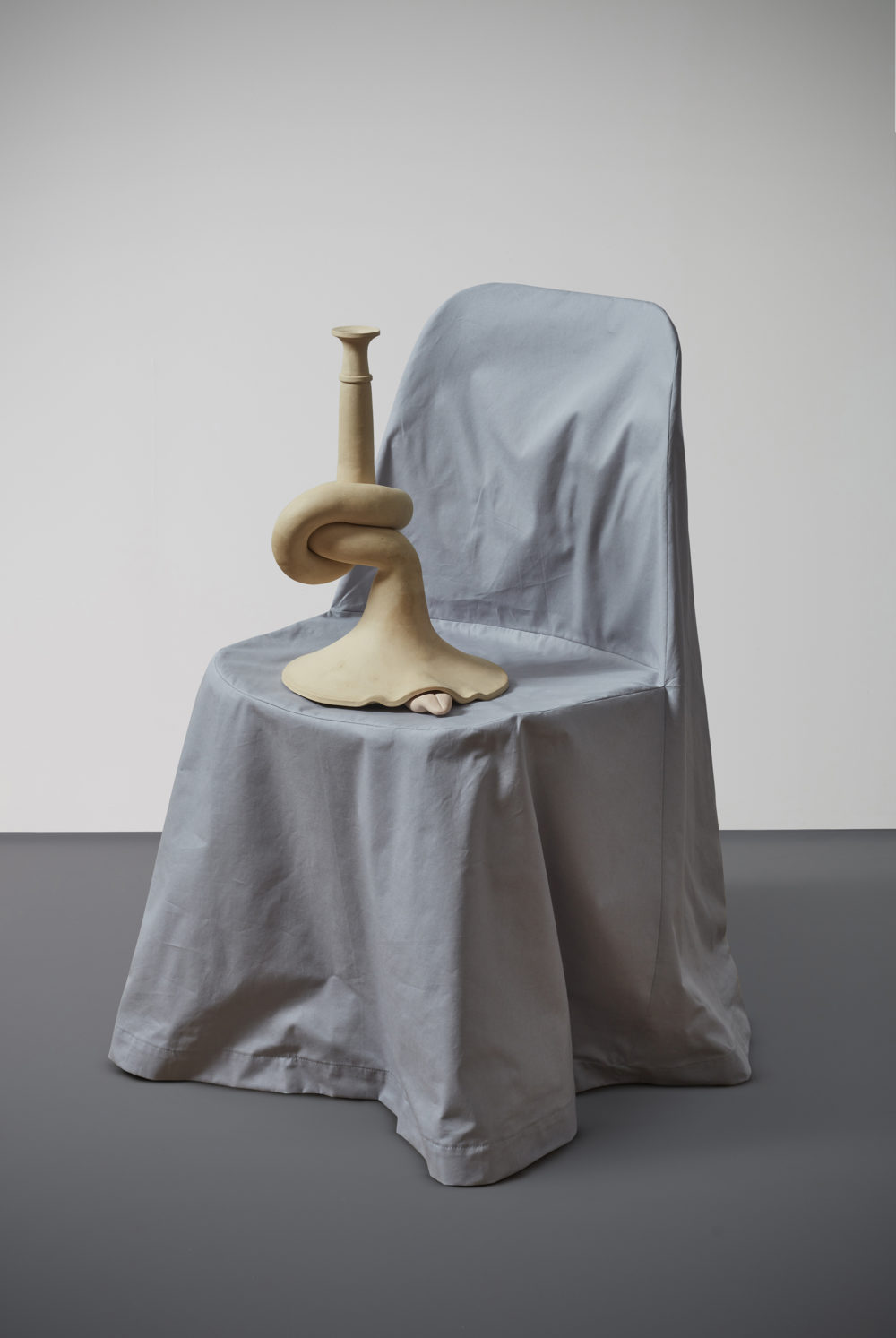 Small sculptural object on a gray chair