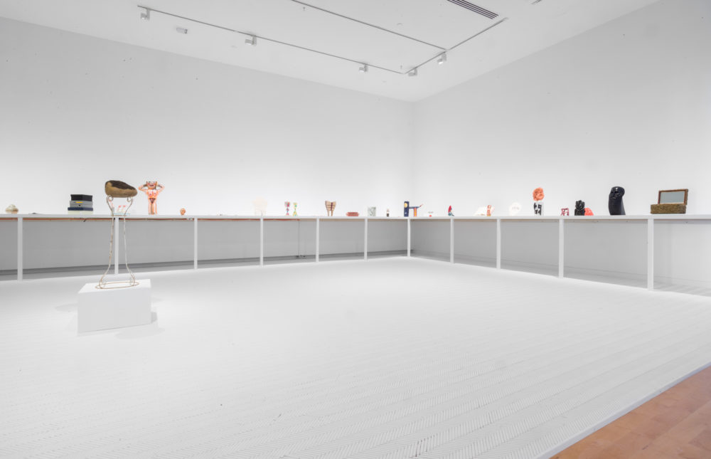 Small sculptural objects on shelf in white room