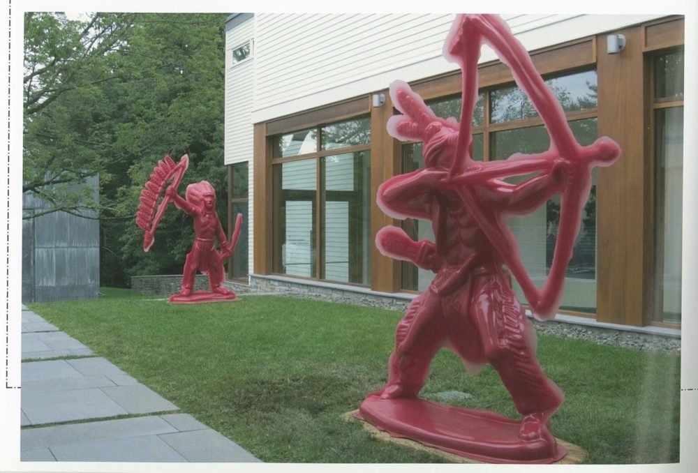 Large red plastic Indian figures installed on Museum lawn.