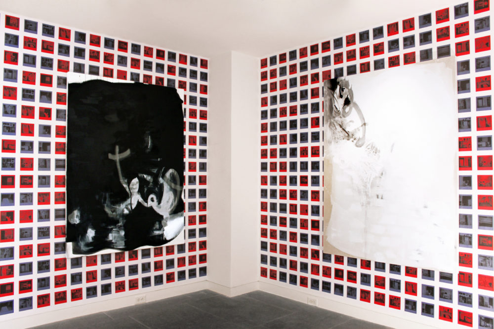 Blue and red squares covering two walls with an abstract painting on each.