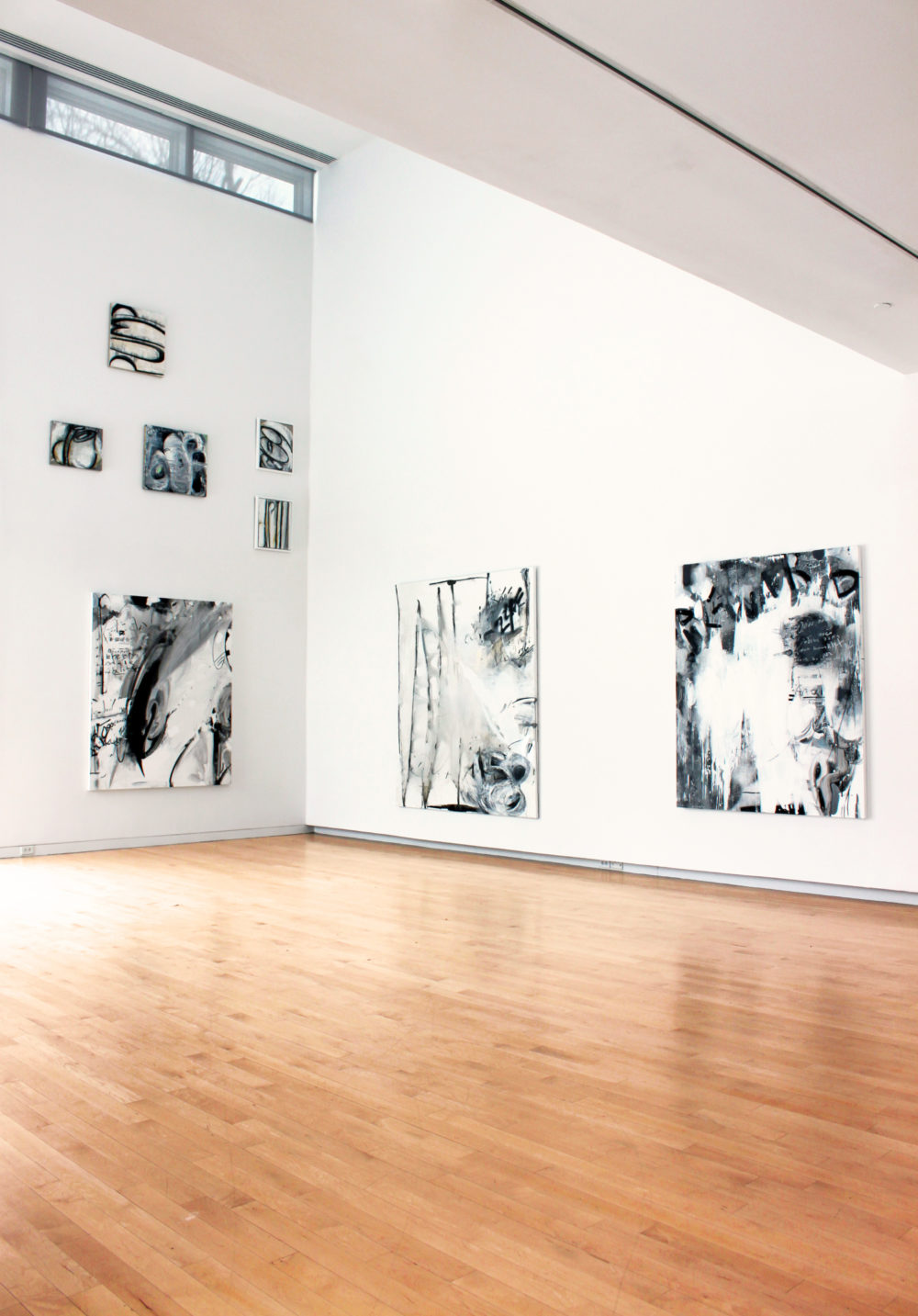 Abstract paintings on white gallery walls.