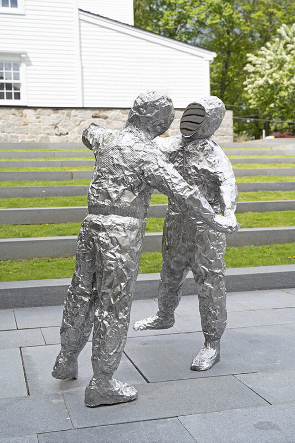 Two figures made out of crumpled baking pans cast in polished stainless steel