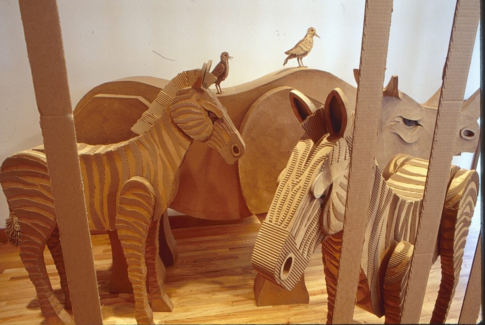 cardboard zebras with a rhino that has two small birds on its back
