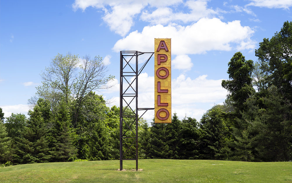 Large yellow sign with red letters reading APOLLO