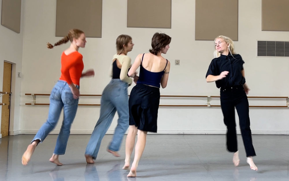 Four dancers rehearsing in a studio.