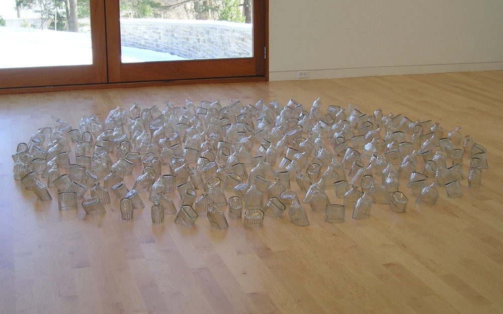 Group of individual clear bottles arranged on a wooden floor