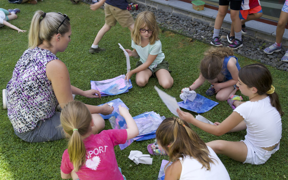 Children work on art projects outside