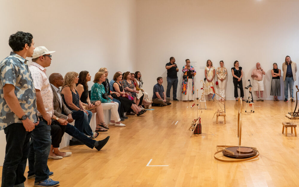 participants listening to a tour guide in an art gallery