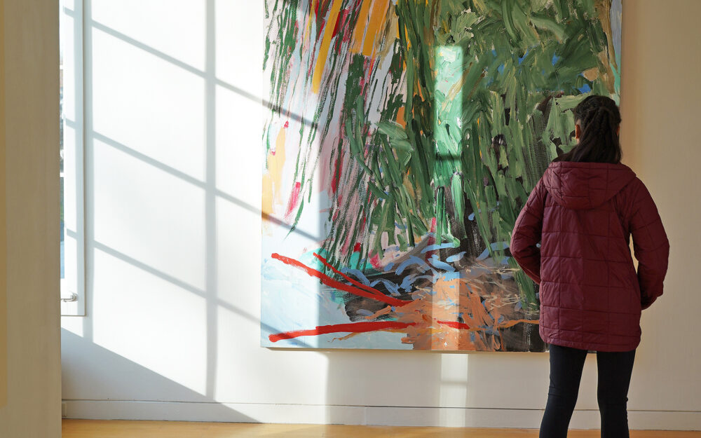 visitor observing a painting on a wall