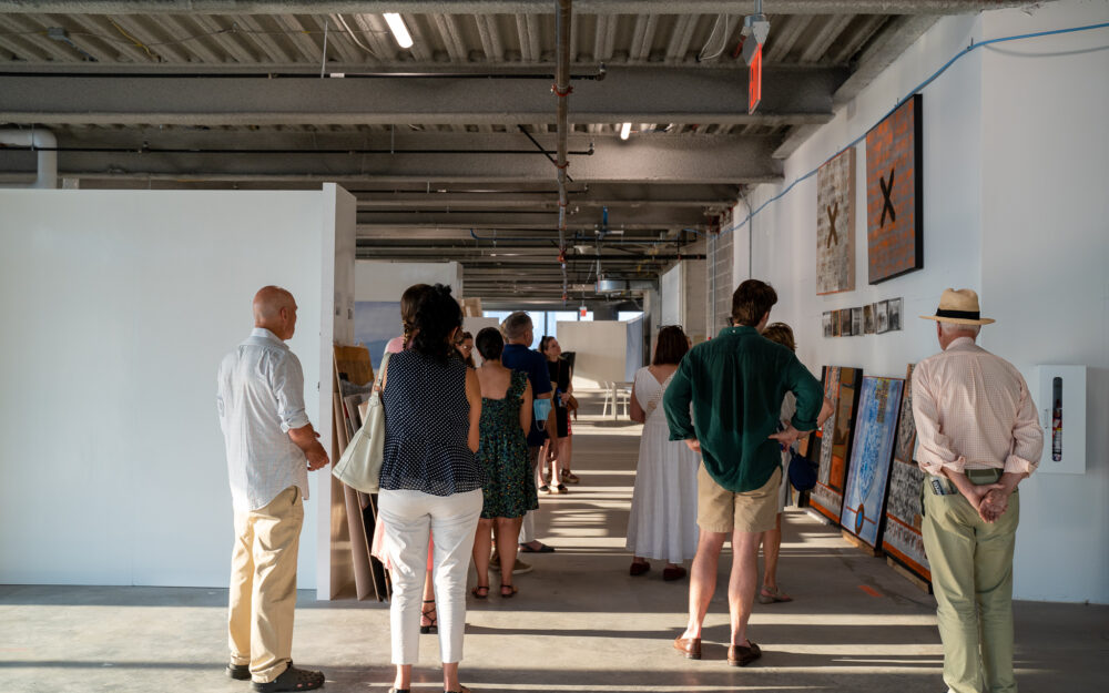 A group of people walking through an art studio