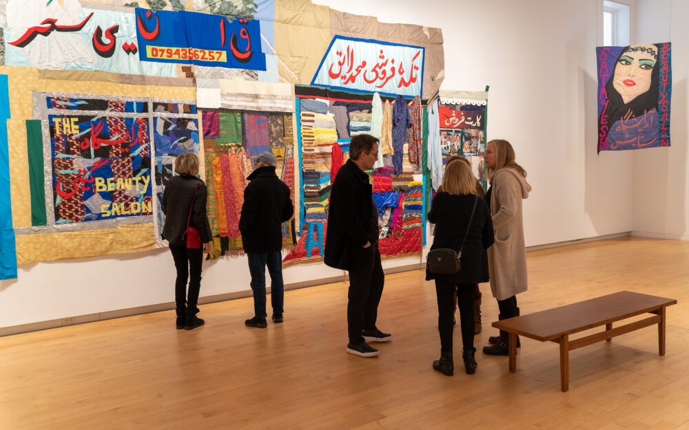 group of people standing and talking in a museum gallery