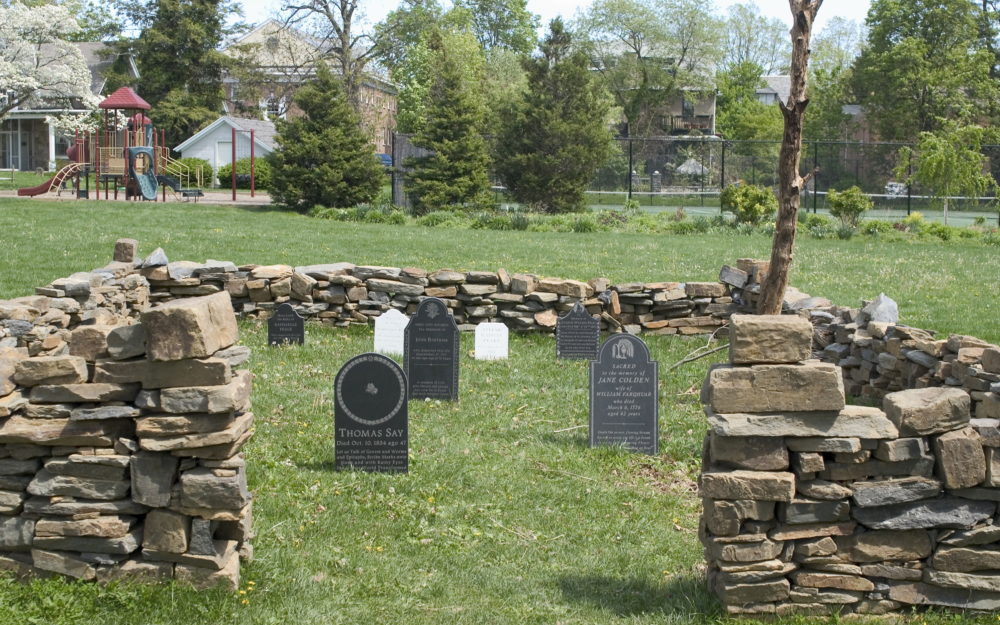 Installed on Museum lawn: Square stone ring with opening in front, "tombstones in center of ring on grass"