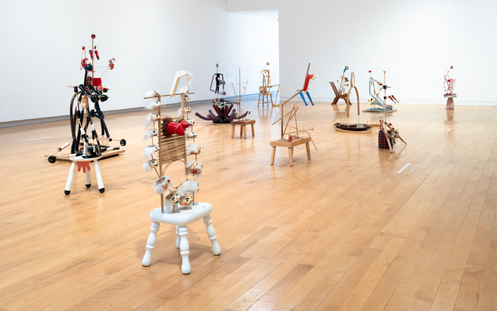 A three quarters view of an installation of figurative sculptures filling a gallery space.