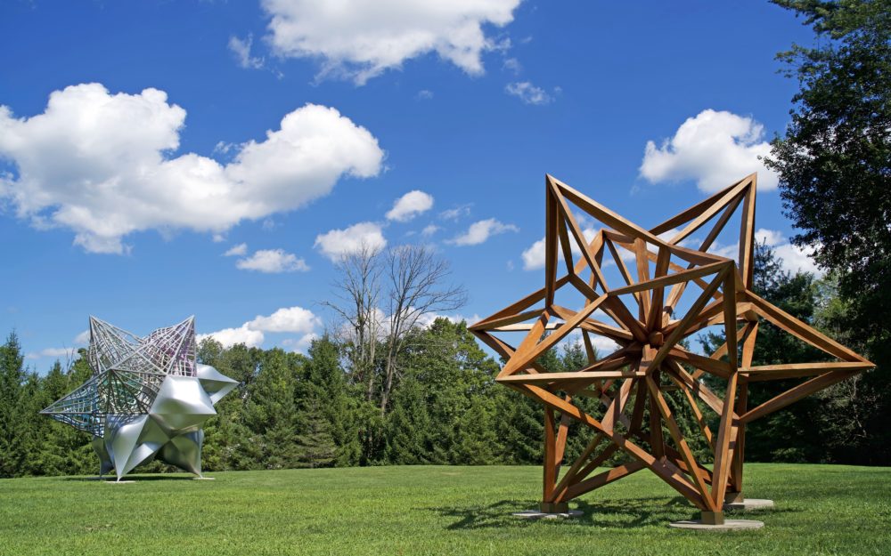 Two large scale star shaped sculptures installed on the grass in the Museum's Sculpture Garden.