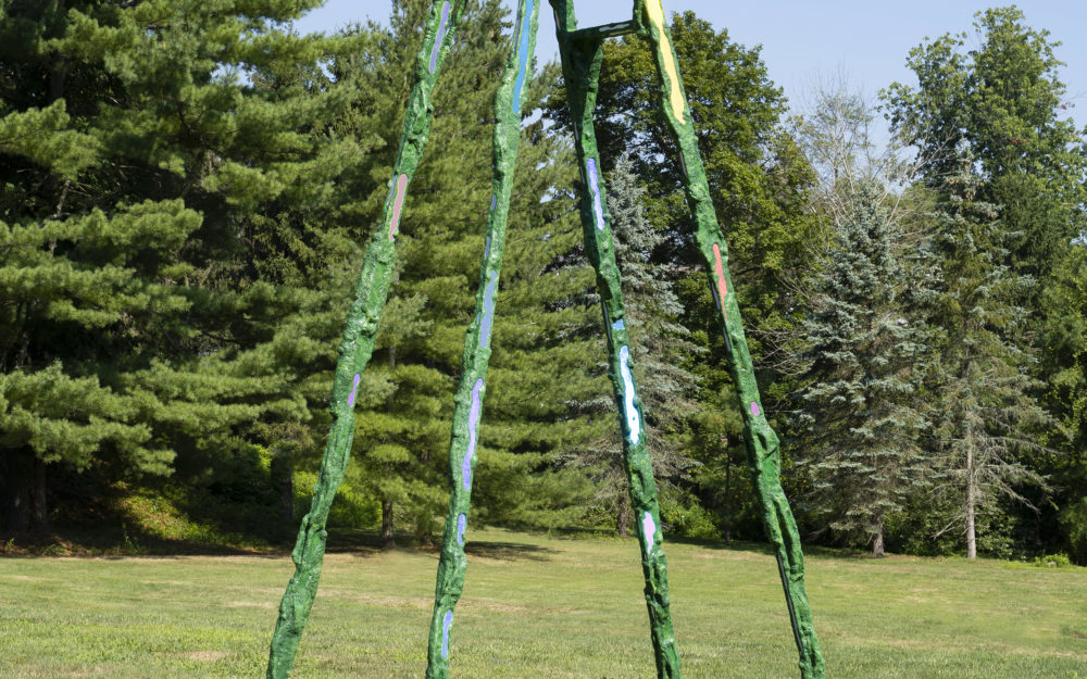 A tall green ladder with holographic elements and "moss" with no rungs except for a couple towards the top.