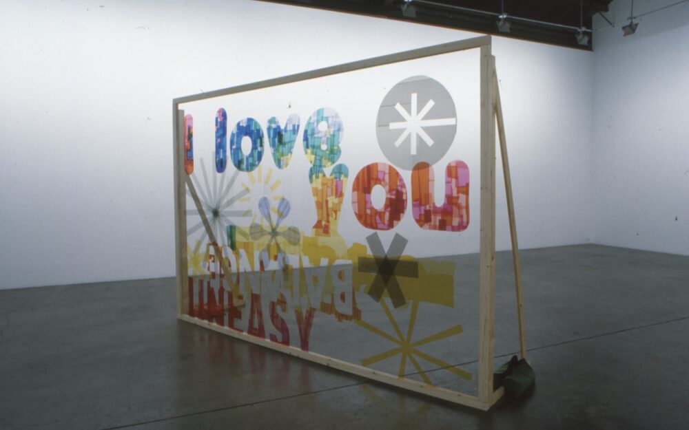 Large sculpture with mixed media elements that says I love you in colored letters
