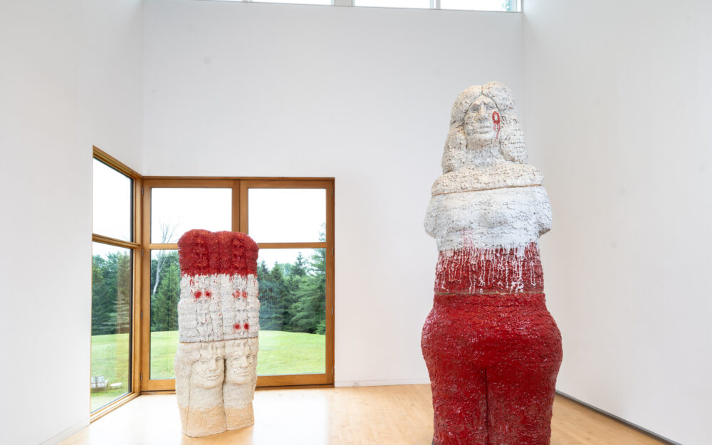 Two large-scale figurative ceramic sculptures in a gallery.