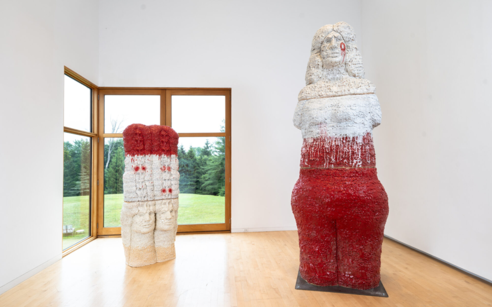Two large-scale figurative ceramic sculptures in a gallery.