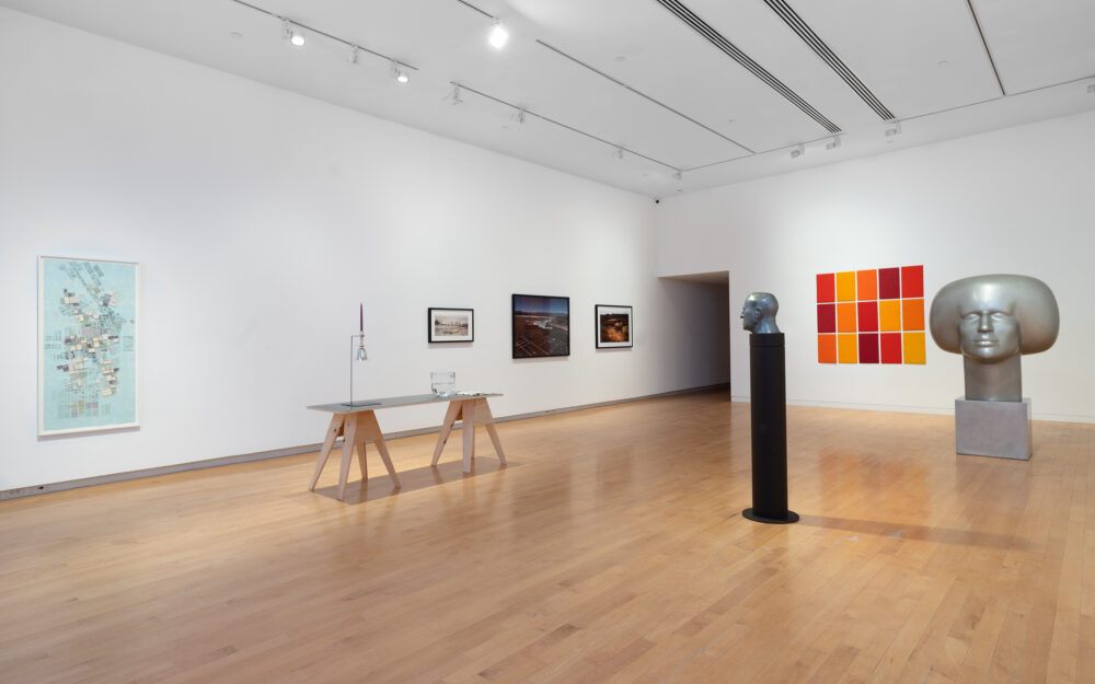 A museum gallery with various artworks relating to the periodic table of elements on display