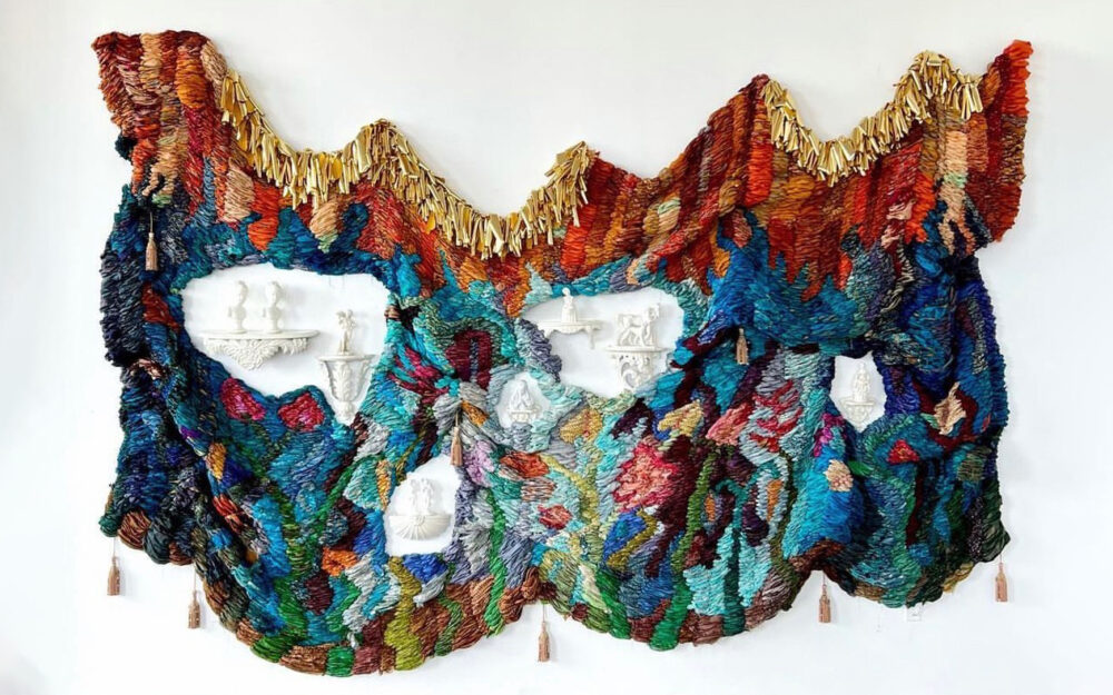 Image of art work made of woven fabric and porcelain objects hanging on a wall