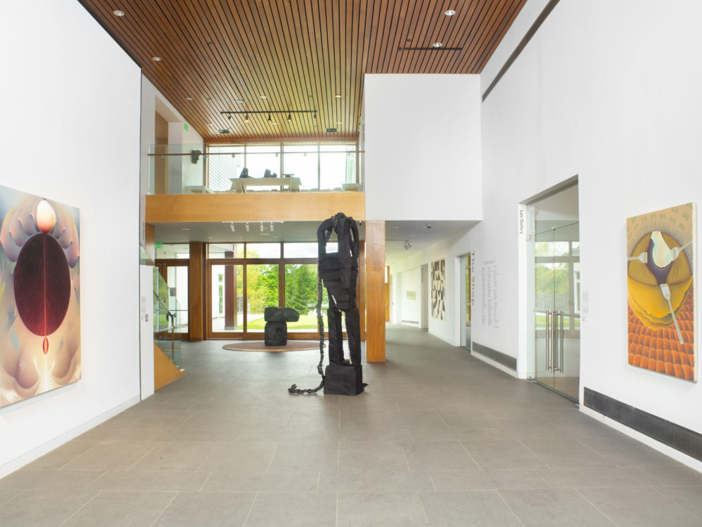 The Museum's lobby with two freestanding sculptures and works hung on the walls.