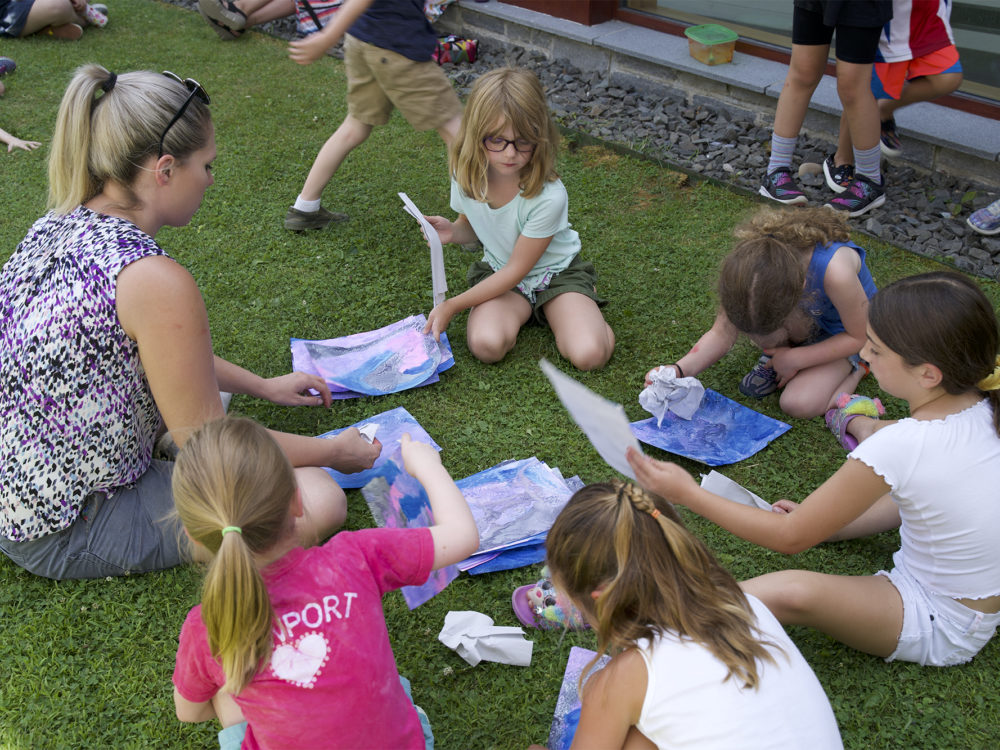 Children work on art projects outside