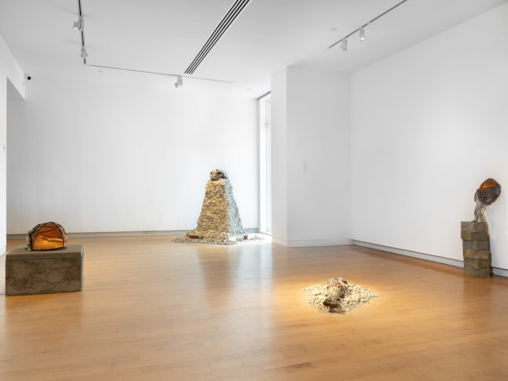 Small sculptures installed in a gallery with figures and architectural forms.