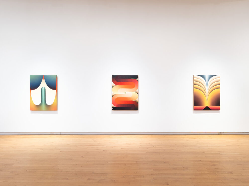 Colorful paintings hung in a row.