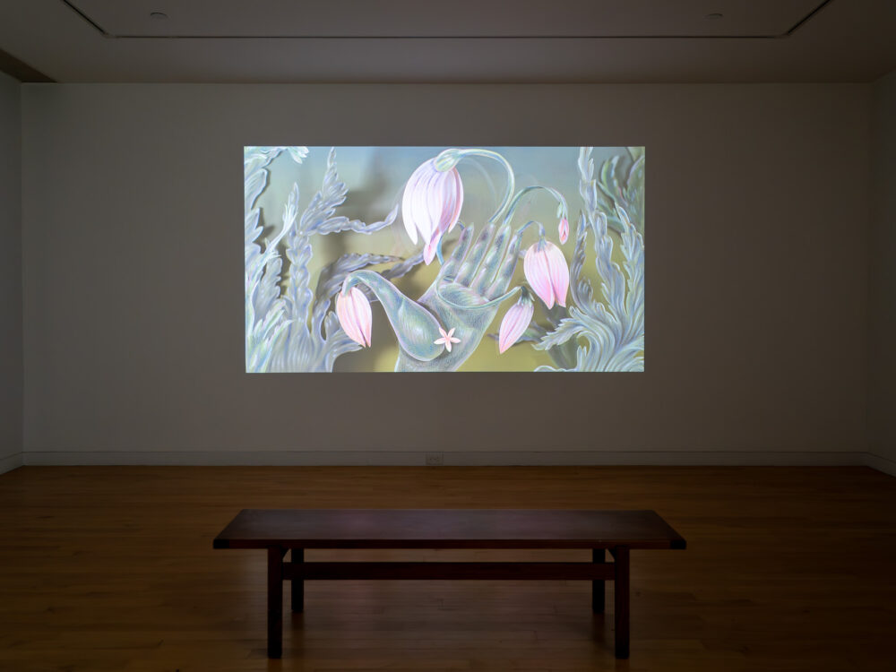 A museum gallery with a video installation projected on a wall