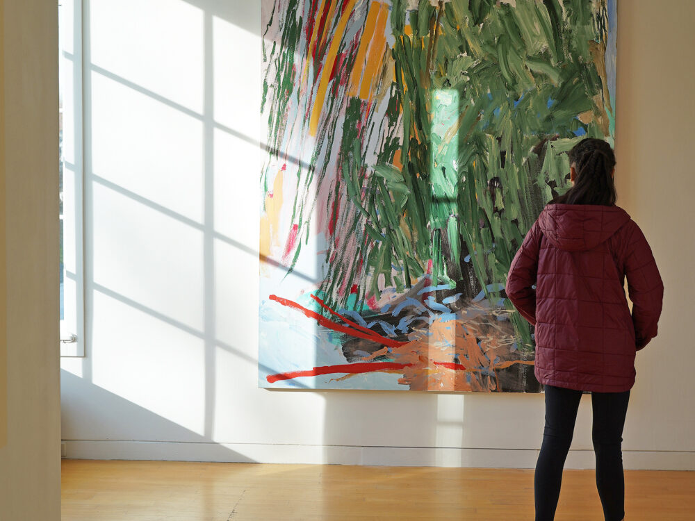 visitor observing a painting on a wall