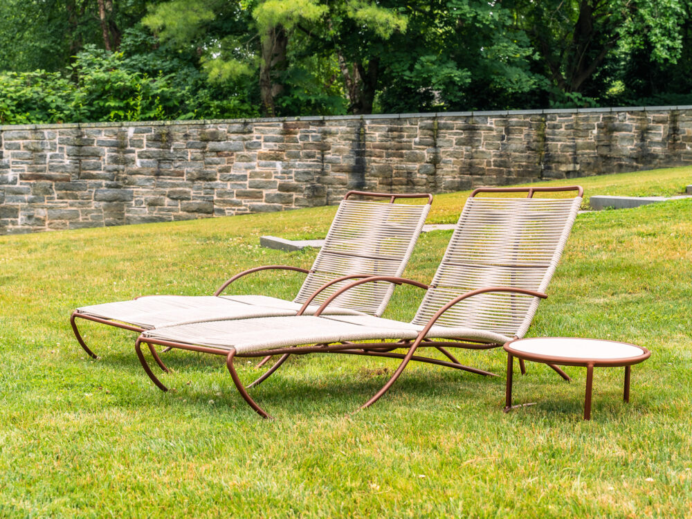 two outdoor chaise lounge chairs in the grass
