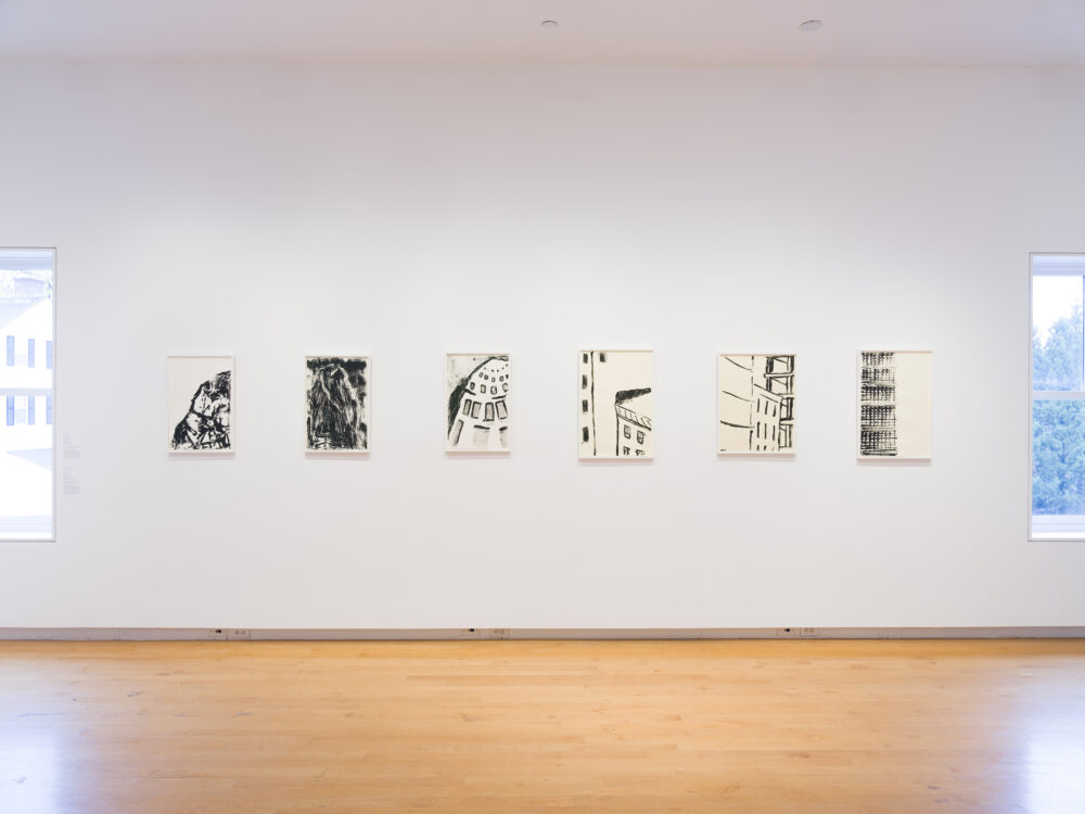 A white wall with a row of small paintings