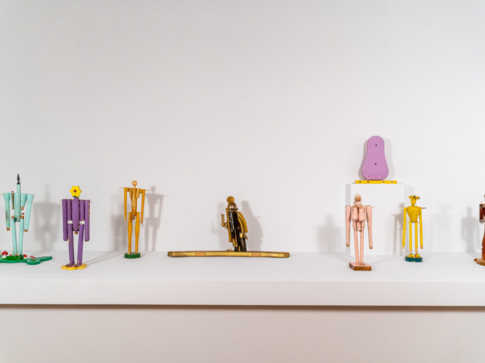 Shelf with small colorful figurative sculptures.