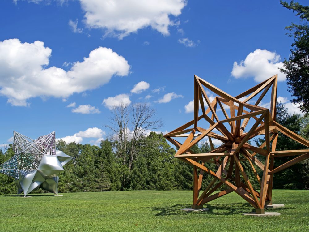 Two large scale star shaped sculptures installed on the grass in the Museum's Sculpture Garden.