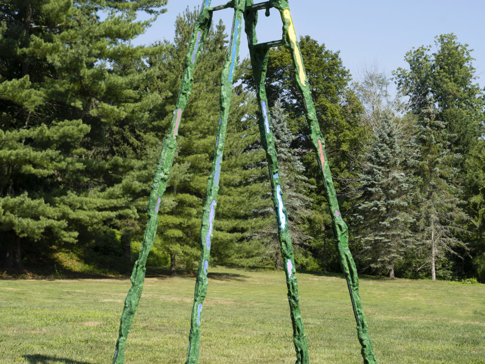 A tall green ladder with holographic elements and "moss" with no rungs except for a couple towards the top.