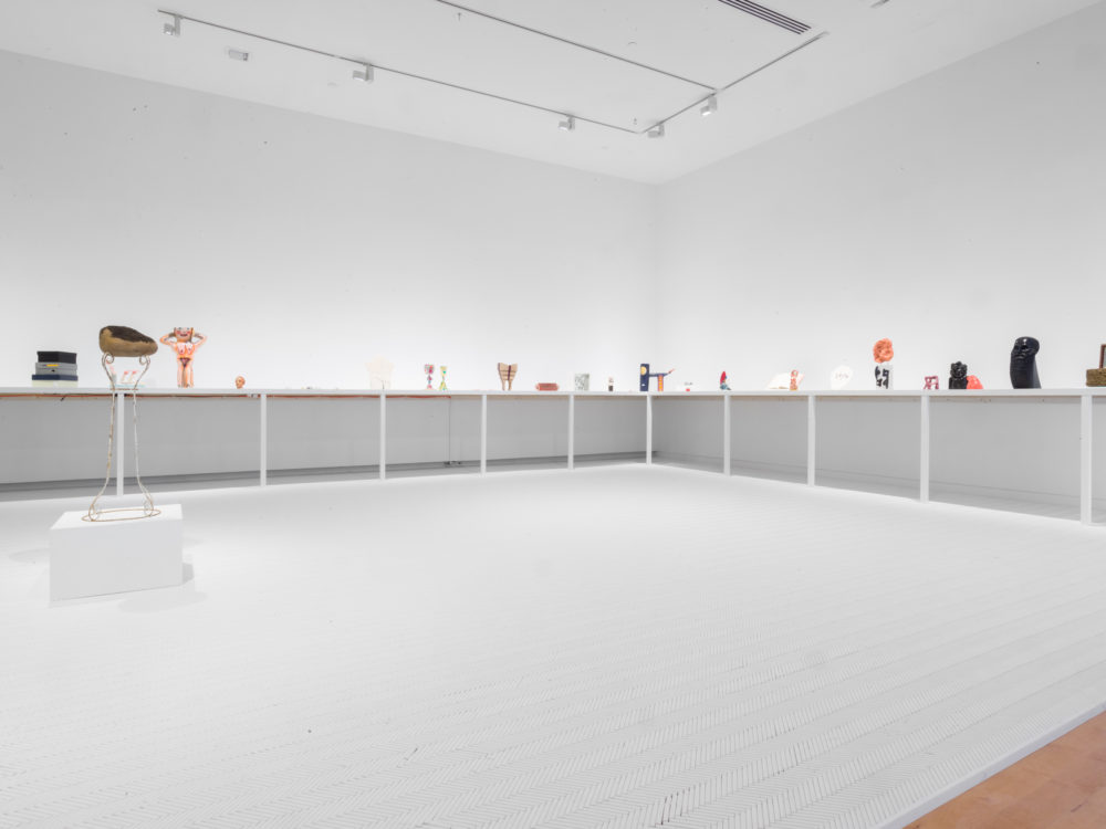 Small sculptural objects on shelf in white room