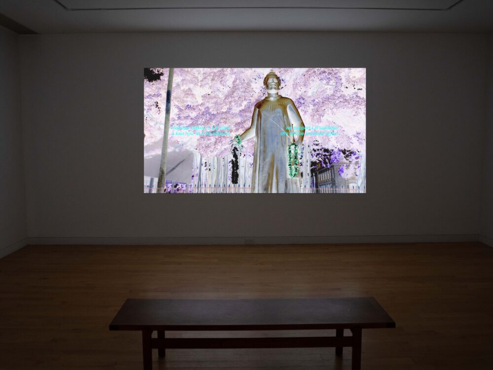 A museum gallery with a large video installation projected on a wall